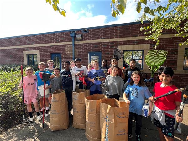 students in front of school showing they have cleaned up the grounds